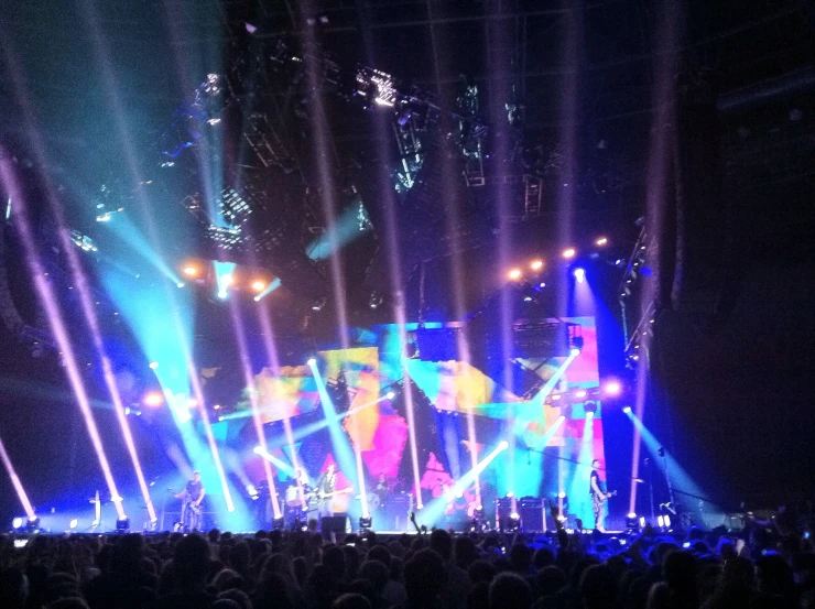 people at a concert with beams of light in the background