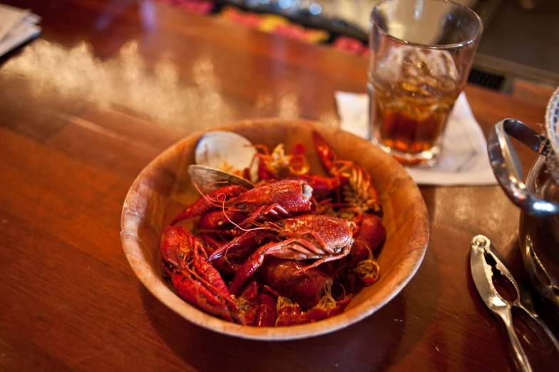 there is a small bowl of craws and a glass of liquid