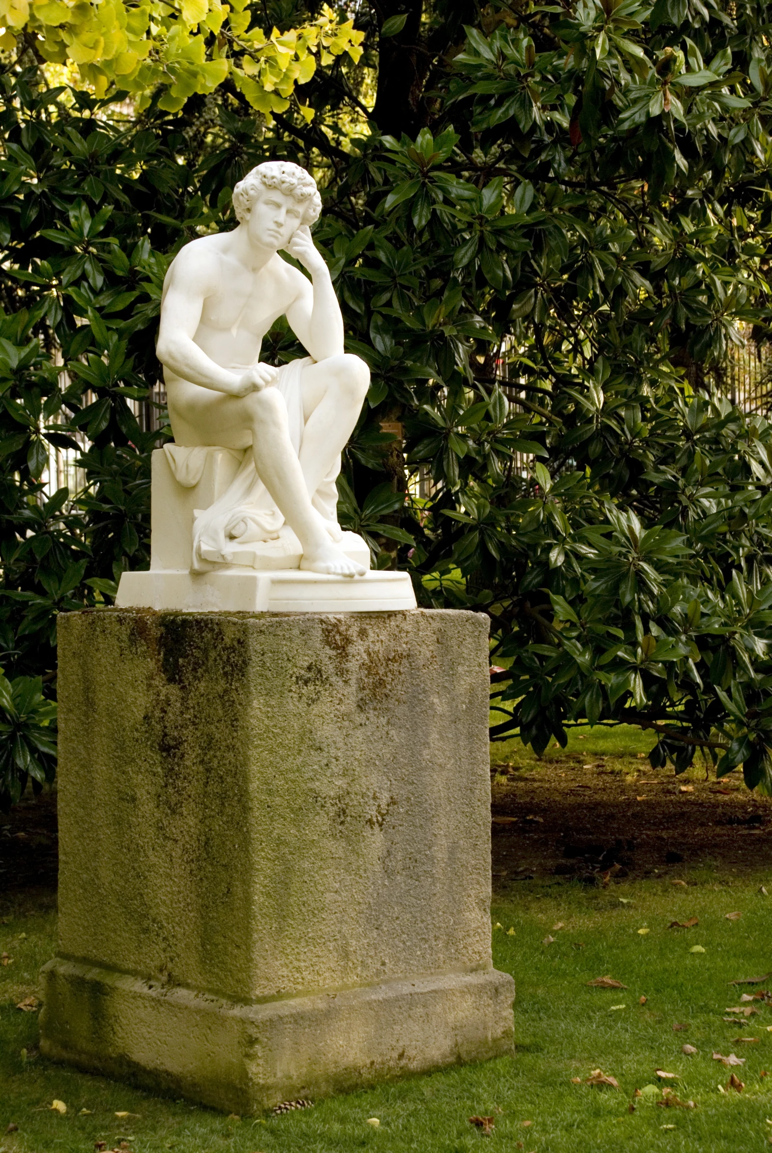 a white statue sitting on top of a cement bench