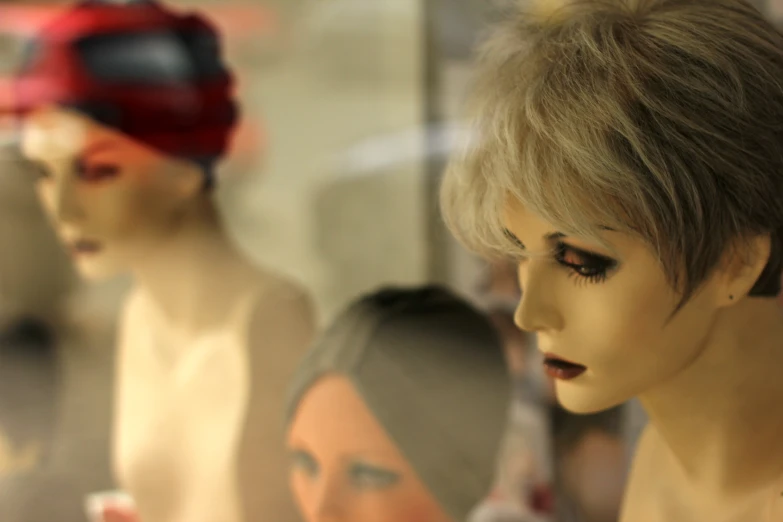 a mannequin's head in front of a display of male mannequins