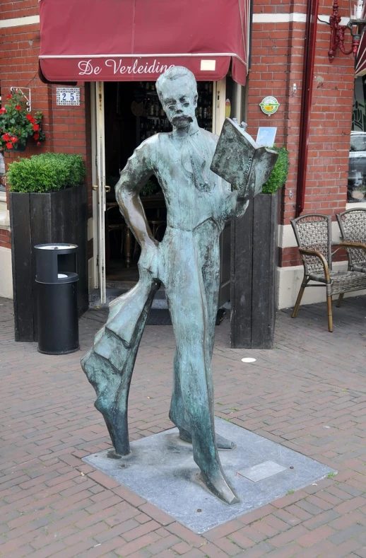 a statue in the middle of a street with a book