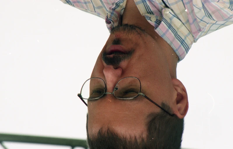 an upside down po of the side view of a man in glasses