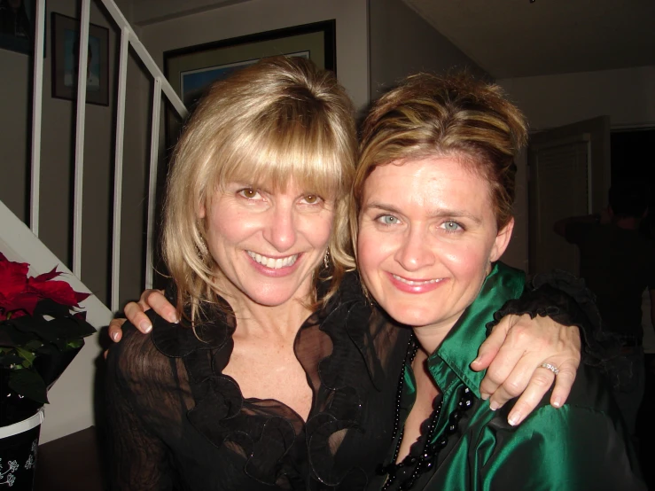 two women in black dresses are standing together