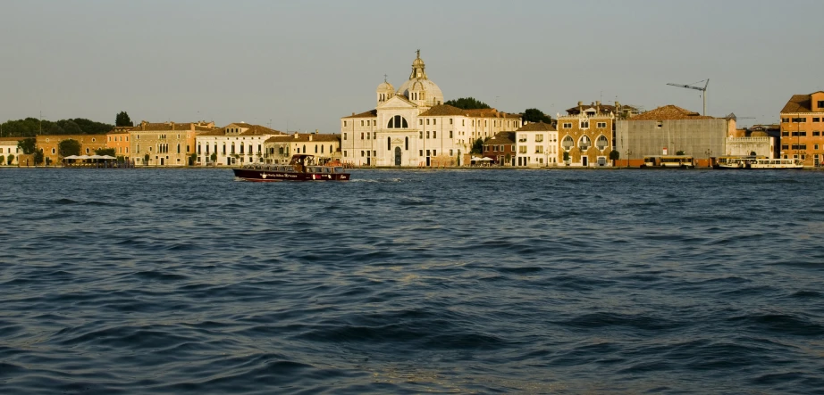 a ship is out on the water near a big city