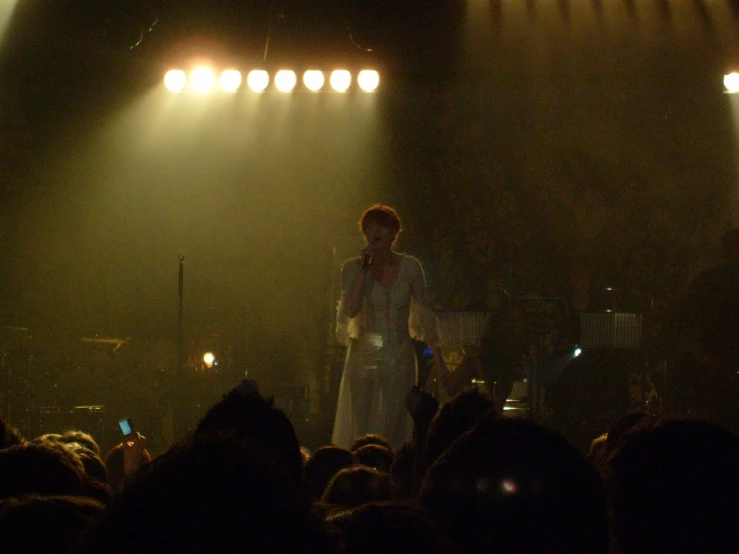 a woman on a stage surrounded by the audience