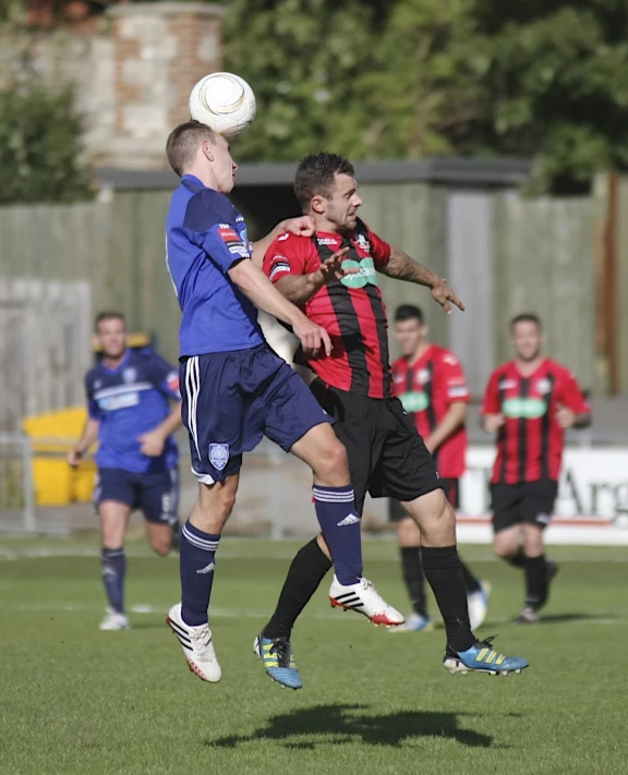 two men playing a game of soccer in the field