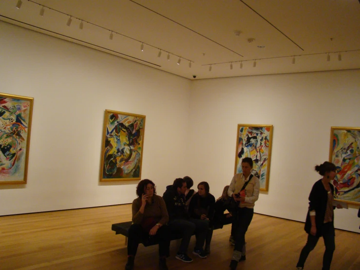 a group of people sitting in an art gallery