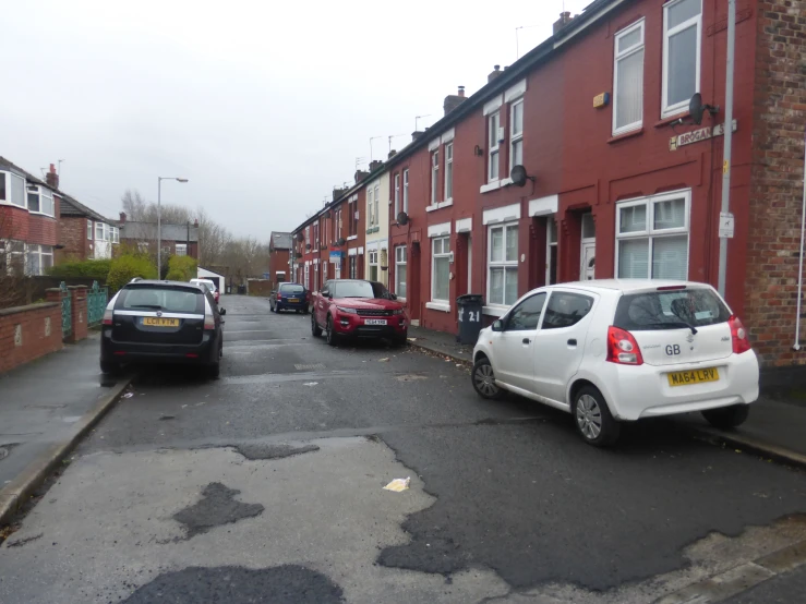 several cars are parked outside a row of houses