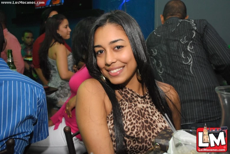 woman smiling in front of group of people at a restaurant