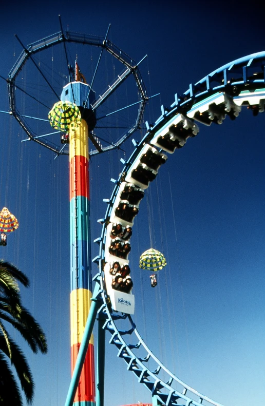 people ride in roller coasters at an amut park