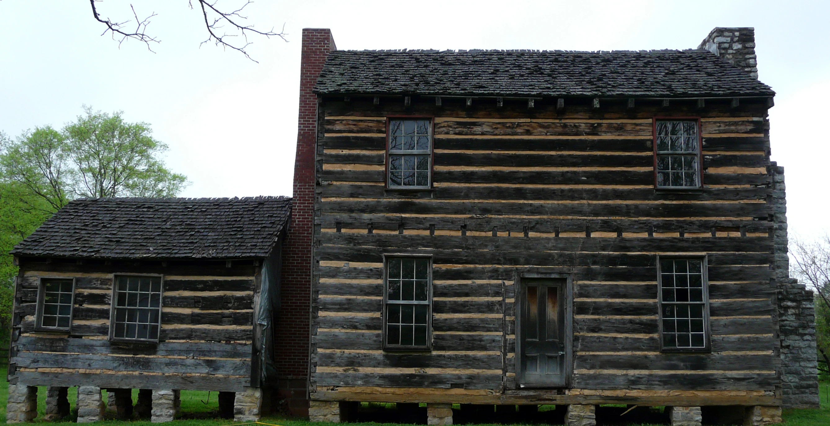 the old log cabin is standing in front of a building