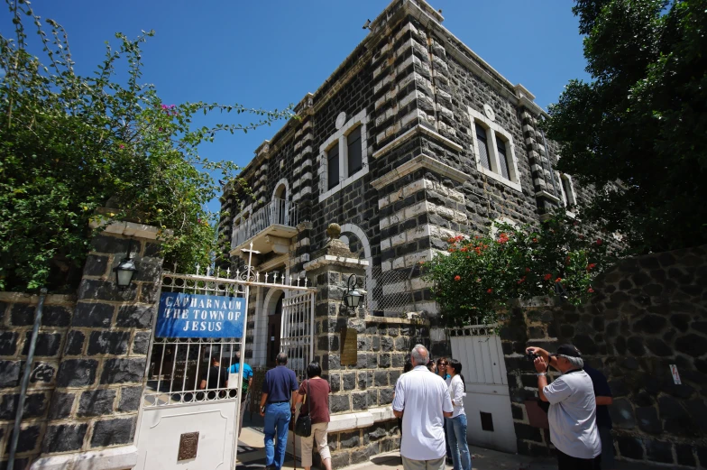 people walking into the gate to a castle like building