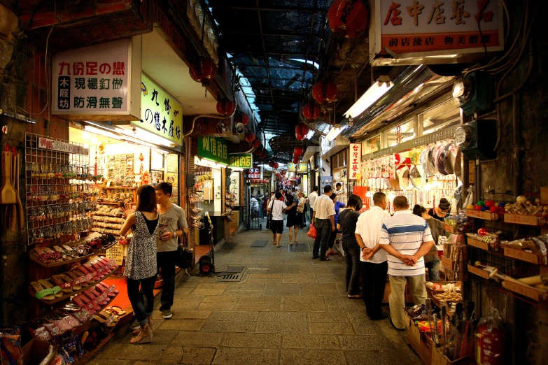 a group of people are walking through an asian market