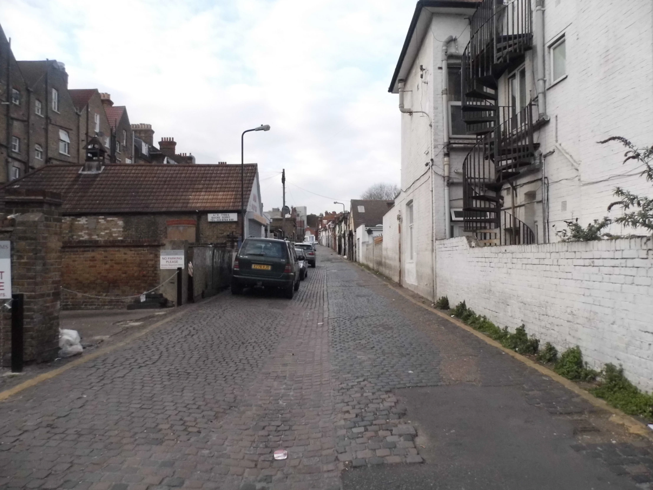 a city street lined with residential buildings and a van parked at the side