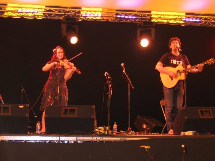 people are performing on stage with musical instruments