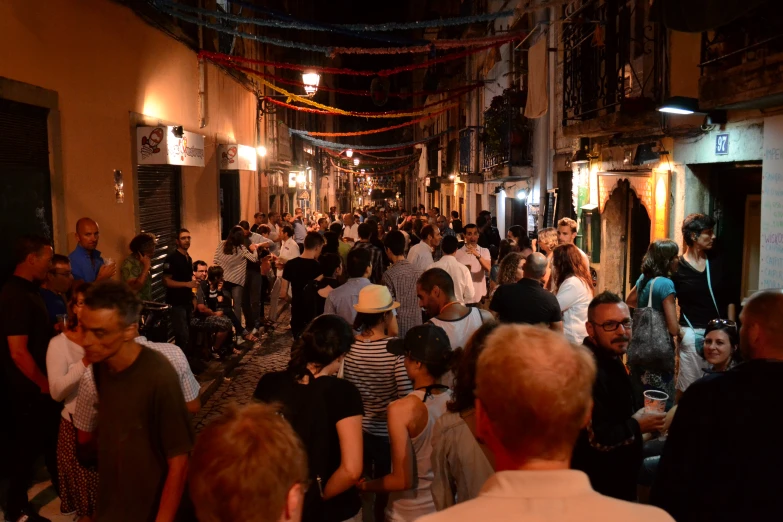 a large group of people walking around a narrow alley