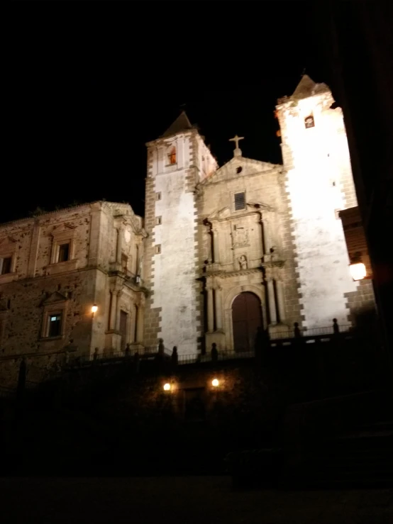 lit up clock tower with a clock on each of it's sides