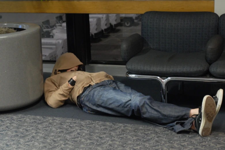 a person in brown jacket laying down with a cell phone