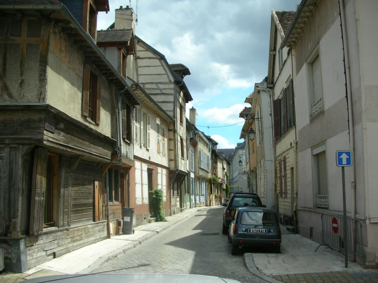 cars parked on a street between two buildings