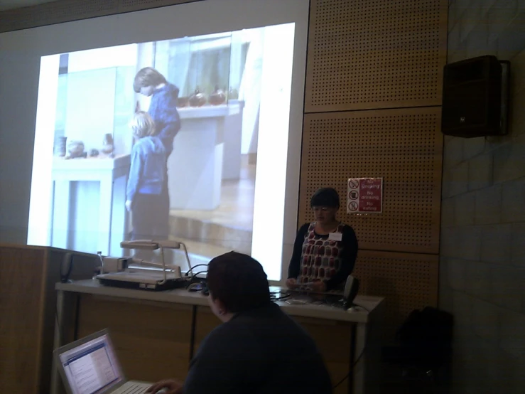 there is a man and woman standing in front of a video screen