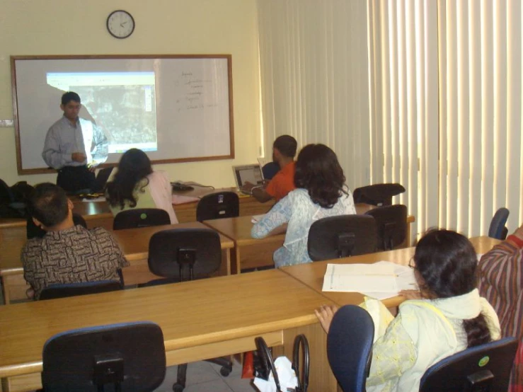 a classroom that is full of people and desks