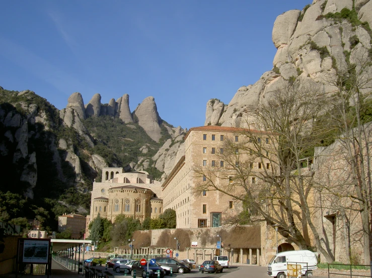 a bunch of parked cars in front of a tall mountain