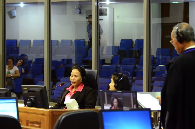 a woman in a courtroom talking to a man