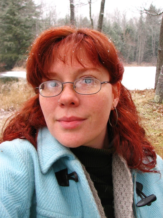 the woman has red hair and blue glasses