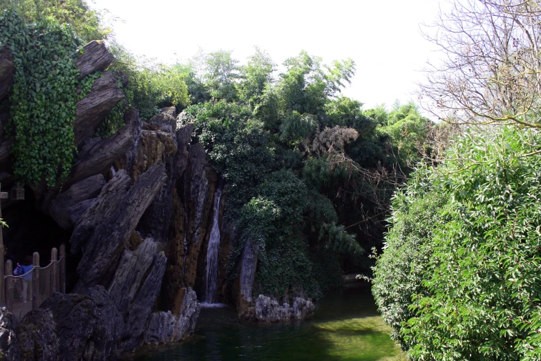 people standing in the middle of an outdoor waterfall