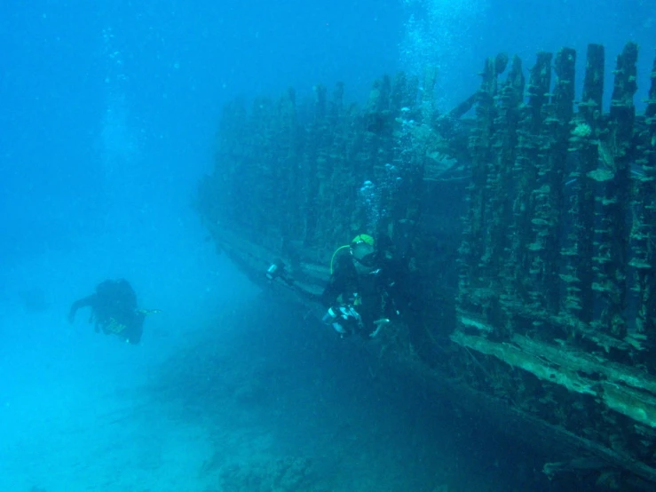 a man is scubain underneath an underwater crate