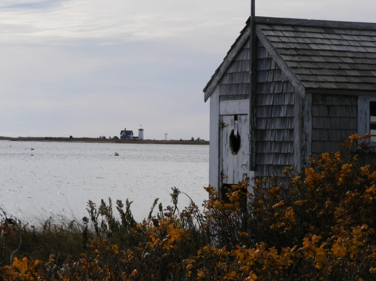 a small wooden boathouse in the middle of a water way