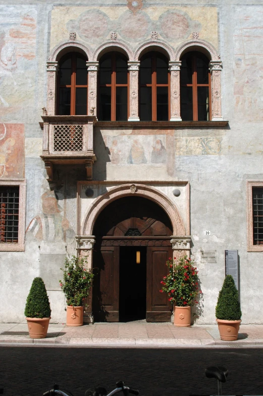 a building that is not very clean and decorated with potted plants on the outside