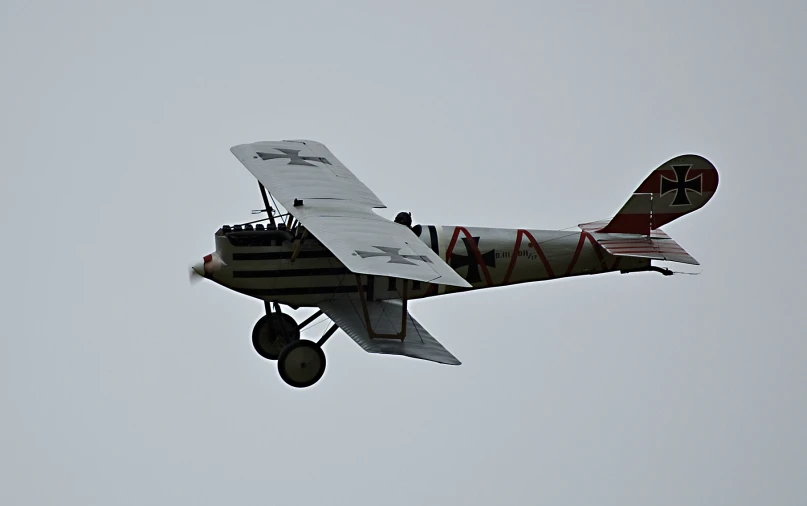 a small airplane flies through the sky on a gray day