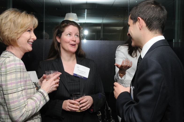 two women and a man smiling together during an event