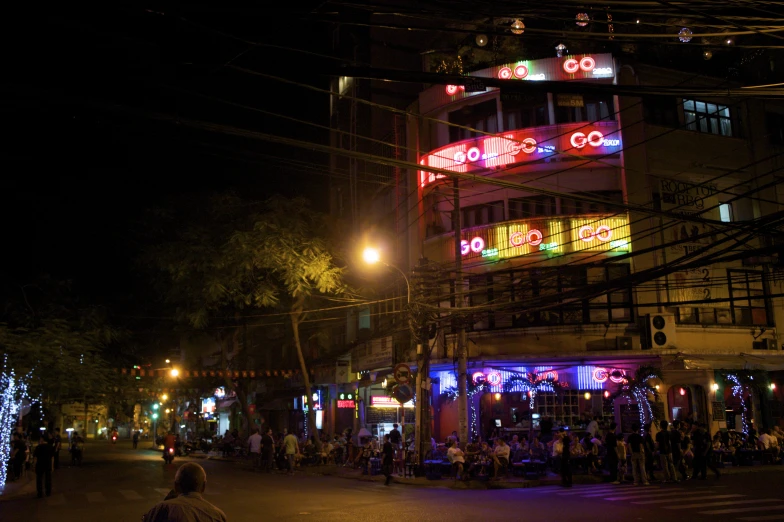 night time scene of illuminated buildings with people on the sidewalk