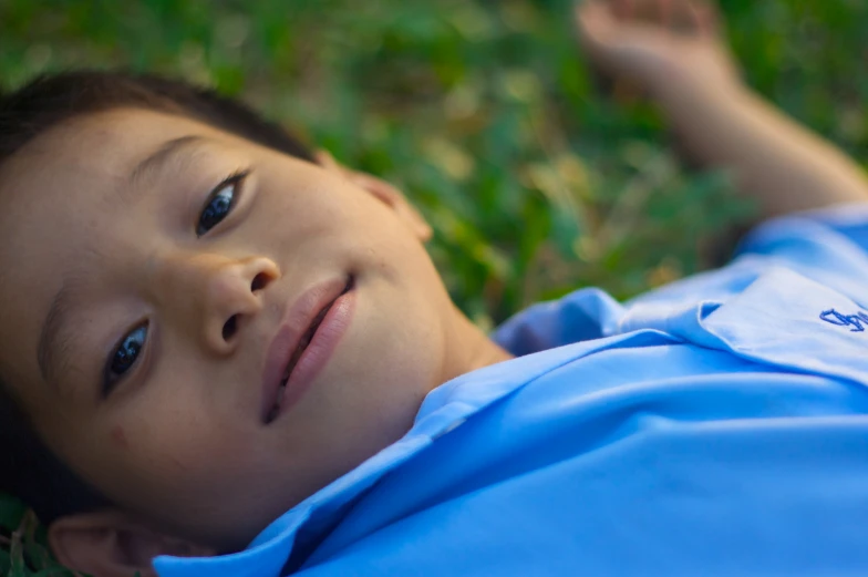 a close up of a young child laying on the ground