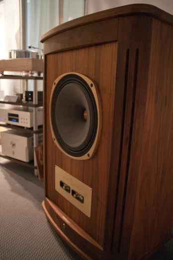 an audio speaker mounted on the front of a wooden cabinet