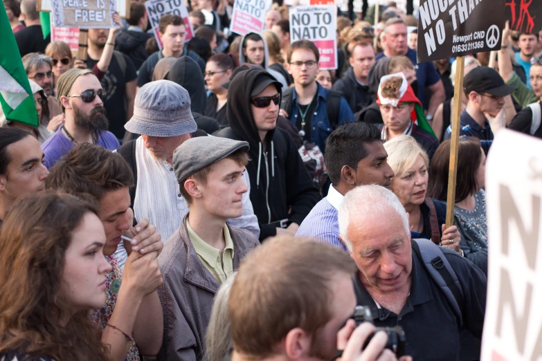 a group of people holding signs in the middle of a rally