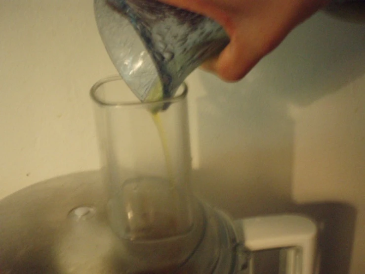 a person pours liquid into a small cup