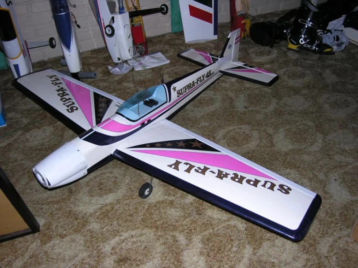 a pink and black model air plane on carpet
