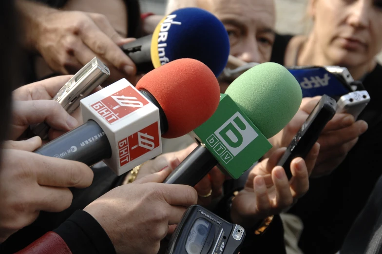 several people in a group making a statement by some microphones