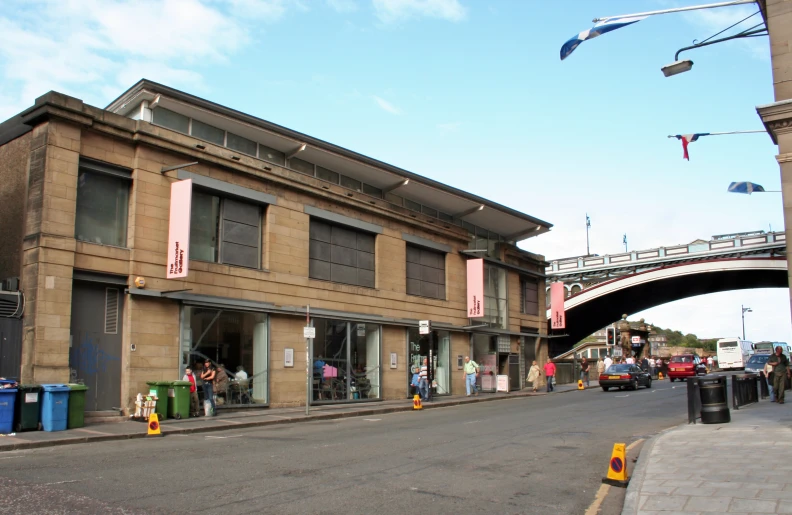 a store front with cars on the street and people walking in it