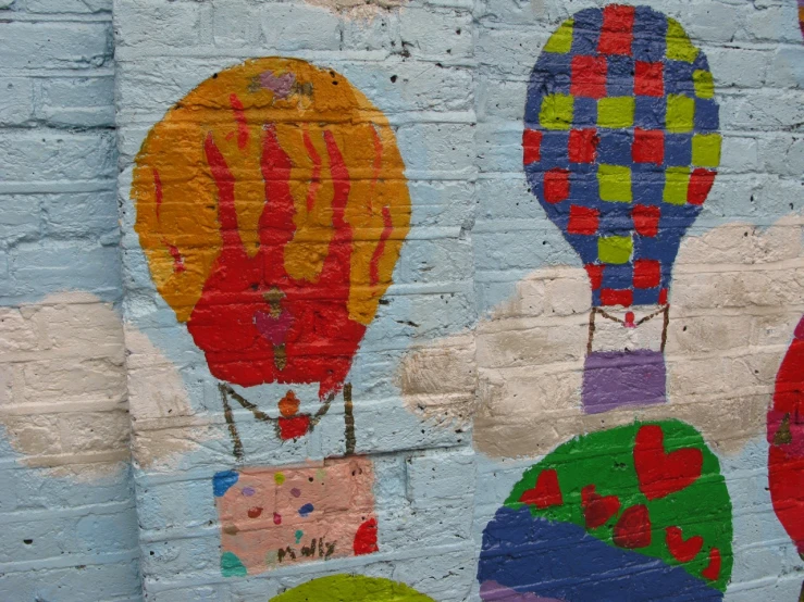 a picture of colorful balloons painted on brick wall