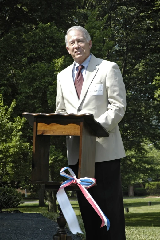 the man in a suit is speaking at an event