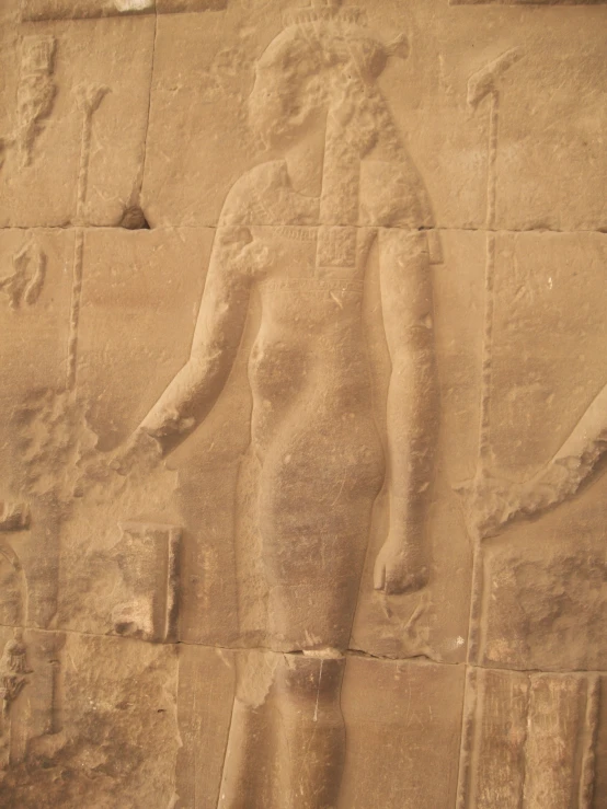 an egyptian stele in the shape of a female with a vase