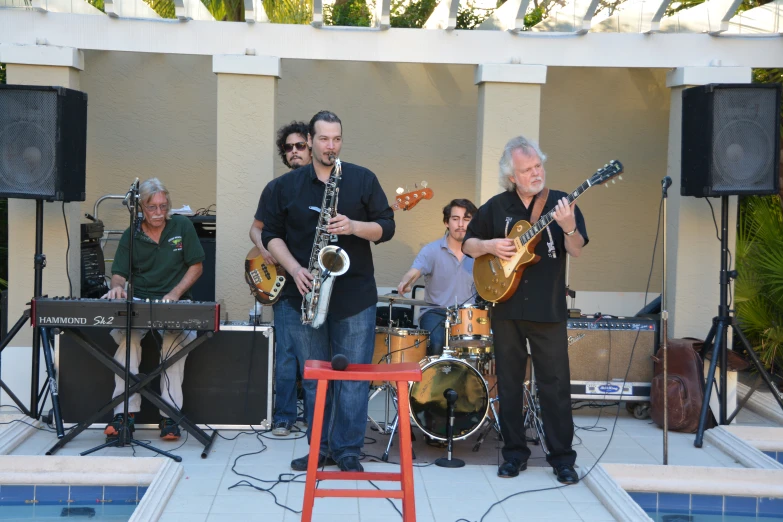 people with music instruments around a pool side