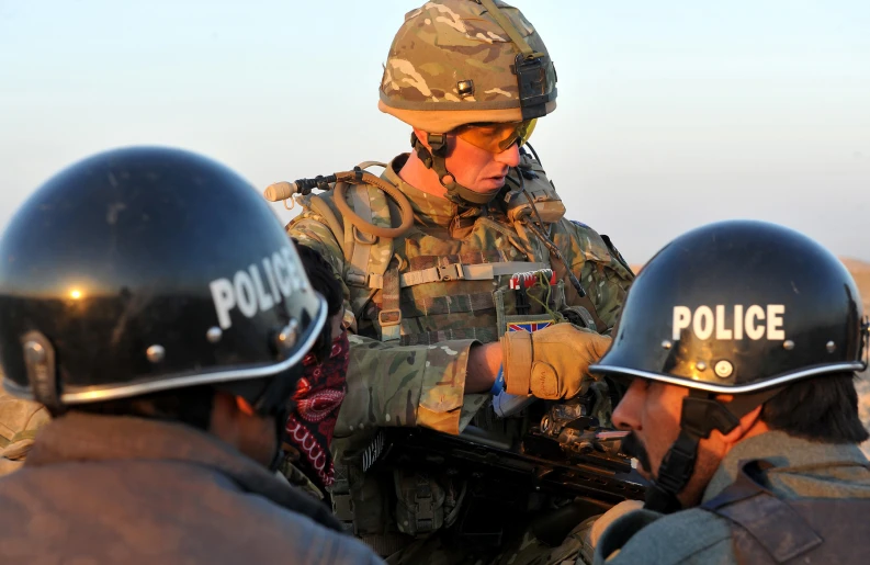 a soldier with a gun talking to three other soldiers