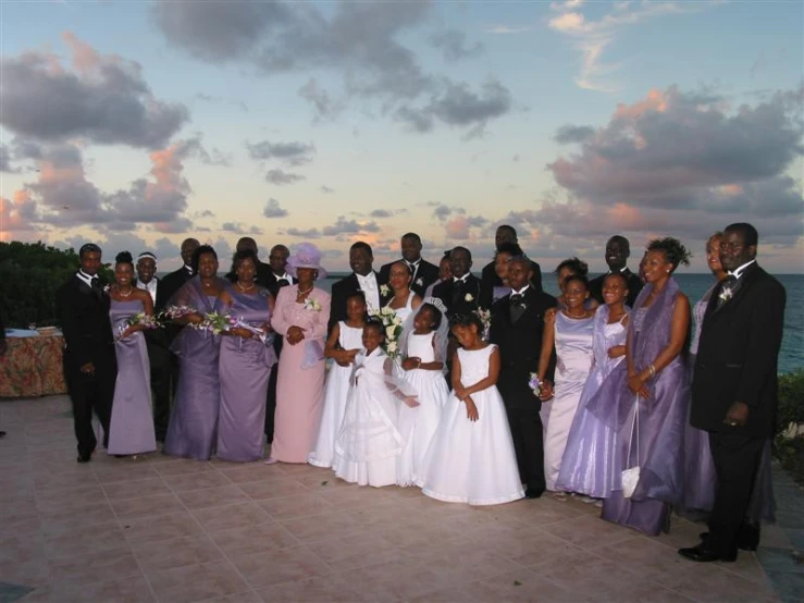 a group of people in wedding attire and ties posing for the camera