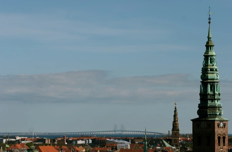 there is an old tower with some spires near a bridge