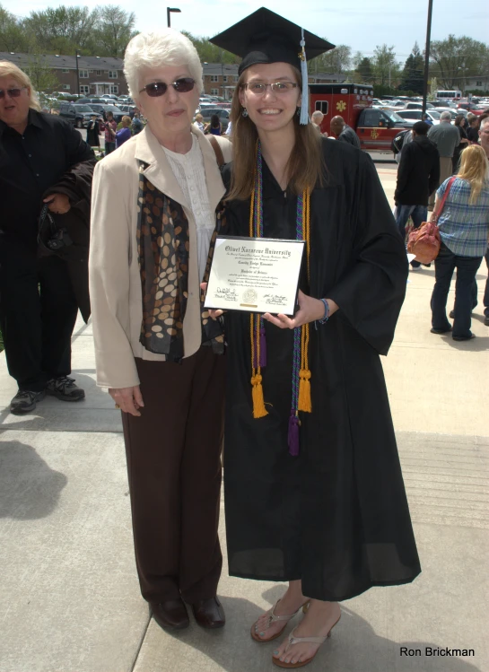 two women are posing for the camera with a fake graduation cap